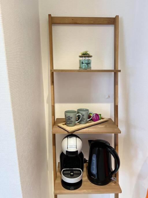 a shelf with cups and a coffee maker on it at Appartement neuf entièrement équipé proche centre in Amiens