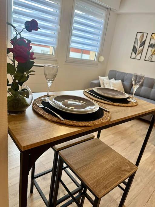 a table with plates and wine glasses on top of it at Appartement neuf entièrement équipé proche centre in Amiens