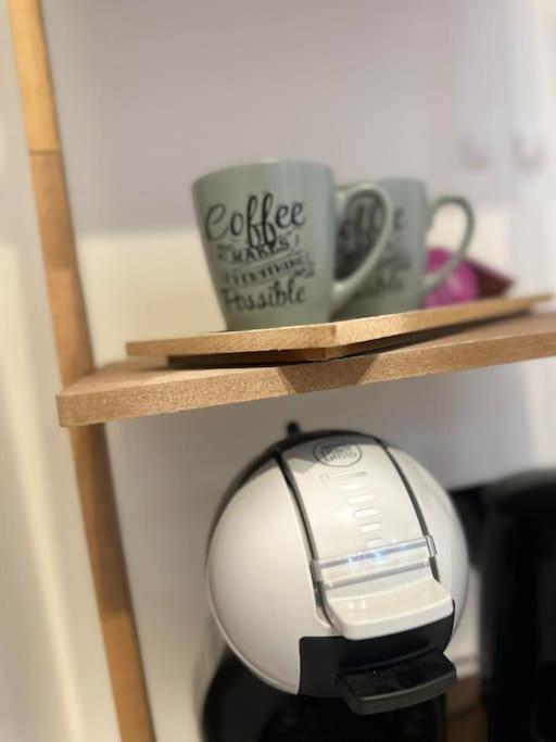 a computer mouse on a wooden shelf with a coffee cup at Appartement neuf entièrement équipé proche centre in Amiens