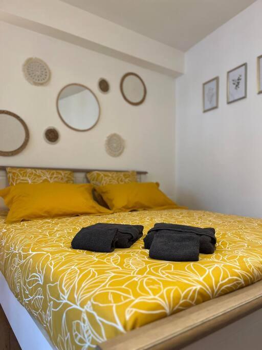 a bedroom with a yellow bed with two towels on it at Appartement neuf entièrement équipé proche centre in Amiens