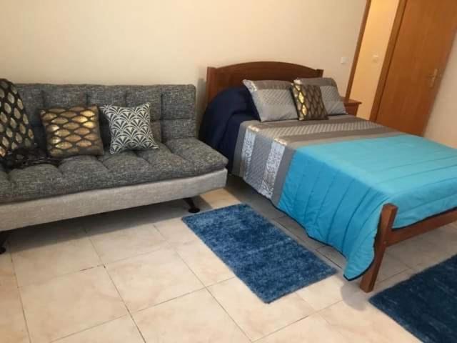 a living room with a couch and a bed at caminho da praia da maiata in Porto da Cruz