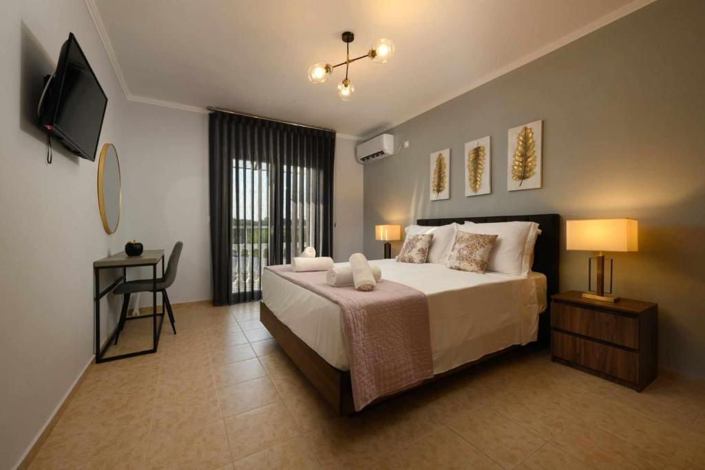 a bedroom with a bed and a television in it at Villa Alina in Lefkimmi
