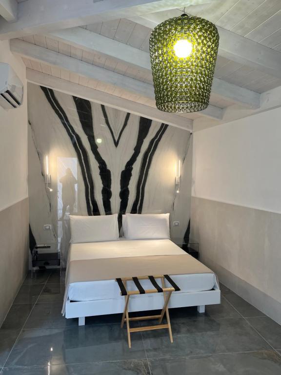 een slaapkamer met een bed en een kroonluchter bij San Pietro Home in San Pietro in Bevagna