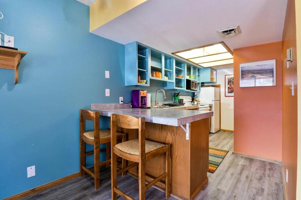 a kitchen with blue walls and a counter with stools at Near Downtown Adventure Nest - Rose Tree 4 in Moab