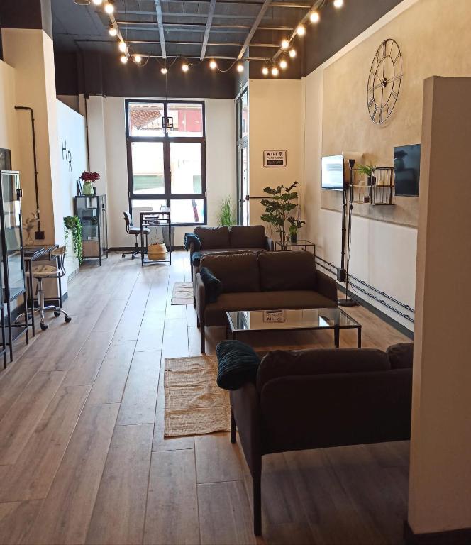 a large living room with couches and a table at Albergue HR in Sarria