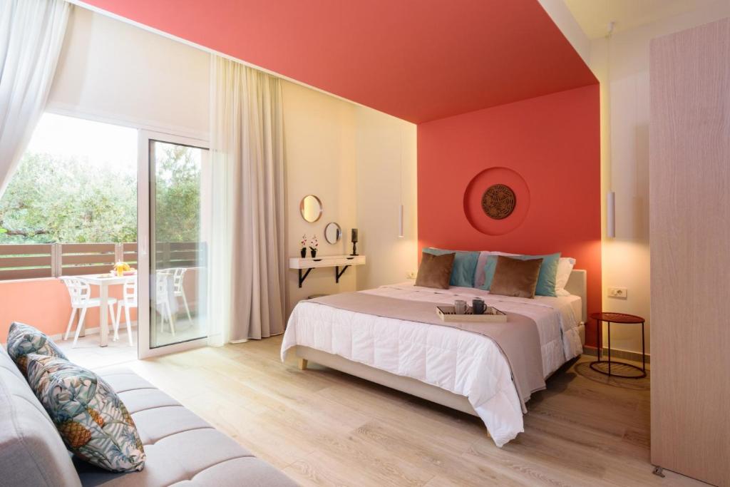 a bedroom with a bed with an orange wall at Iliana Apartments in Falasarna