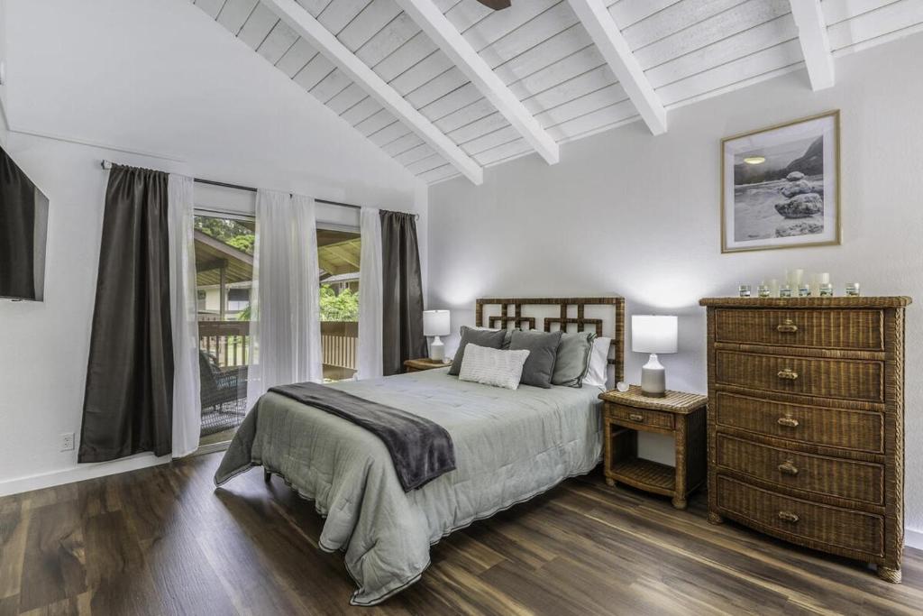 a white bedroom with a bed and a dresser at Sandpiper 216B condo in Princeville