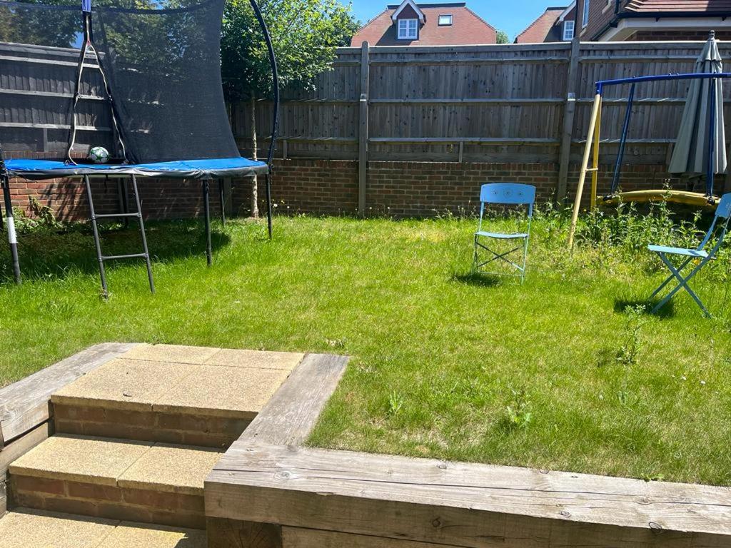 um quintal com duas cadeiras e um trampolim em Croydon Near London em Shirley