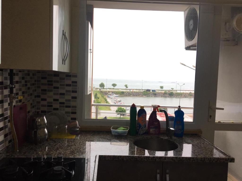 cocina con ventana y vistas al agua en Site daire, en Arsin