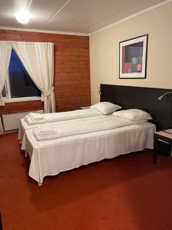 a hotel room with two beds and a window at Skjerdingen høyfjellshotell in Ringebu Østfjell