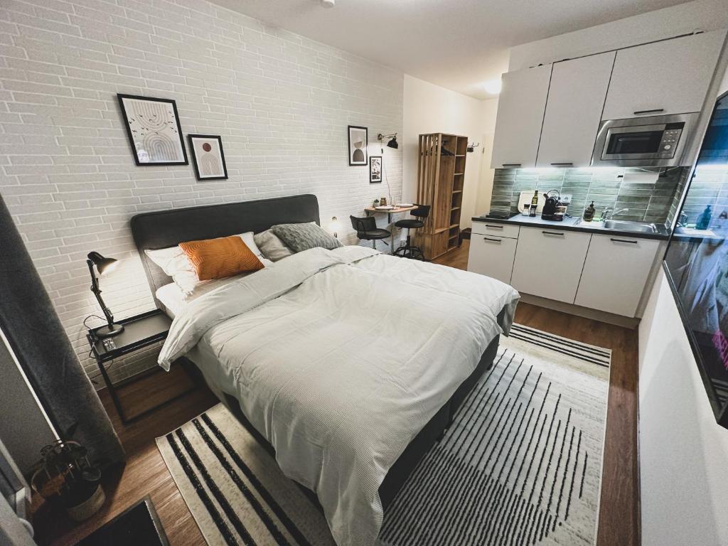1 Schlafzimmer mit einem großen Bett und einer Küche in der Unterkunft Modernes Wohlfühl-Apartment an den Kaiserthermen in Trier