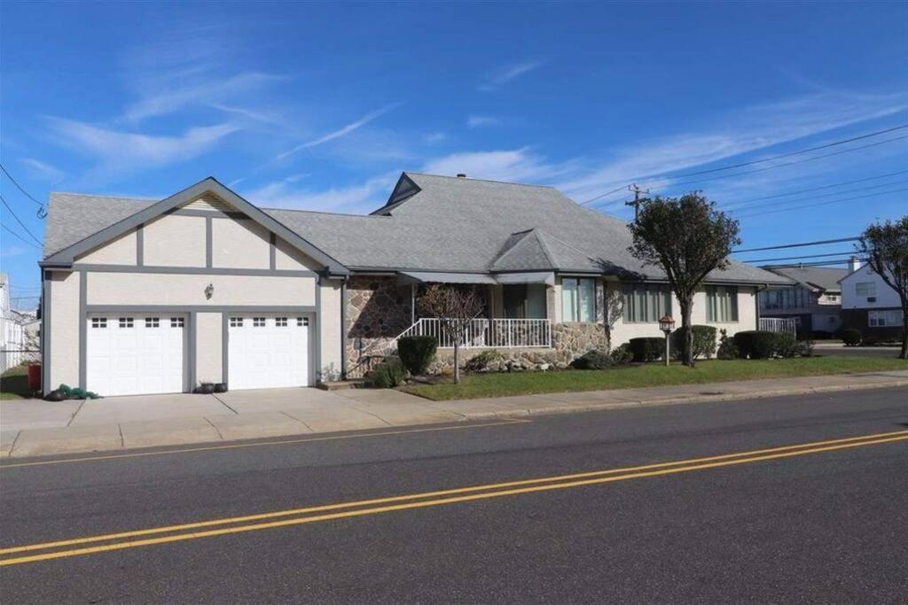 a white house with a garage on a street at Wildwood Crest Beach House in Wildwood Crest