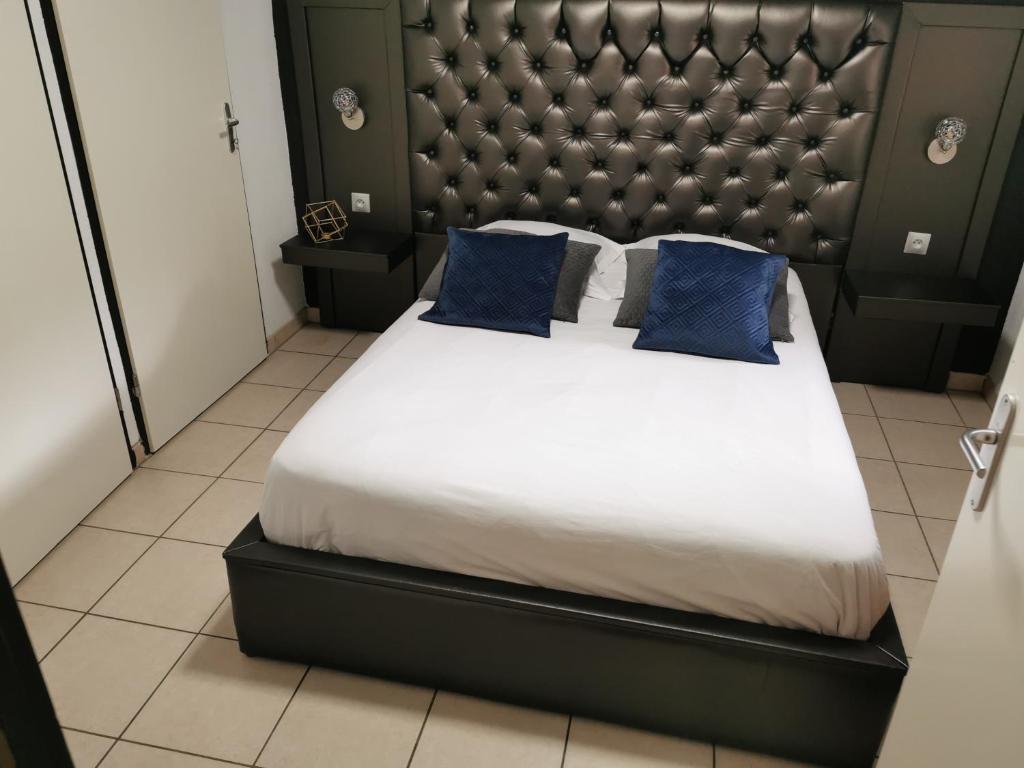 a bedroom with a large bed with blue pillows at Aqua bussy in Bussy-Saint-Georges