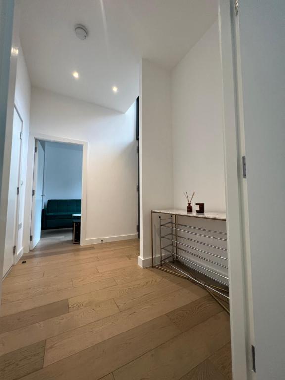 a hallway with white walls and a wooden floor at Luxury Modern 1 Bed Apartment in London