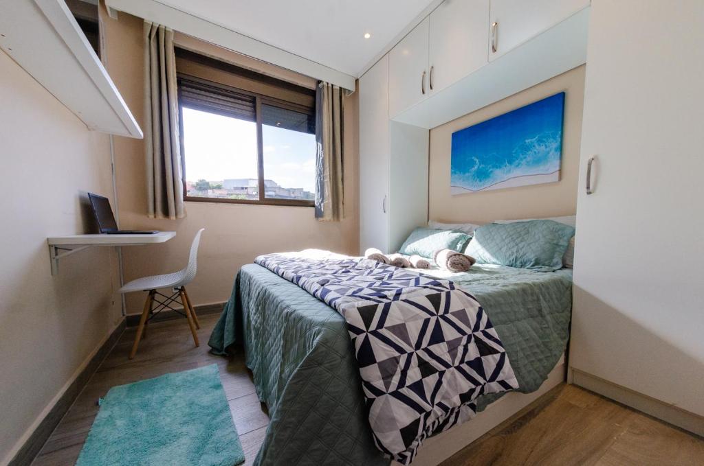 um quarto com uma cama com um cão deitado sobre ela em apartamentos Coração Eucarístico em Belo Horizonte