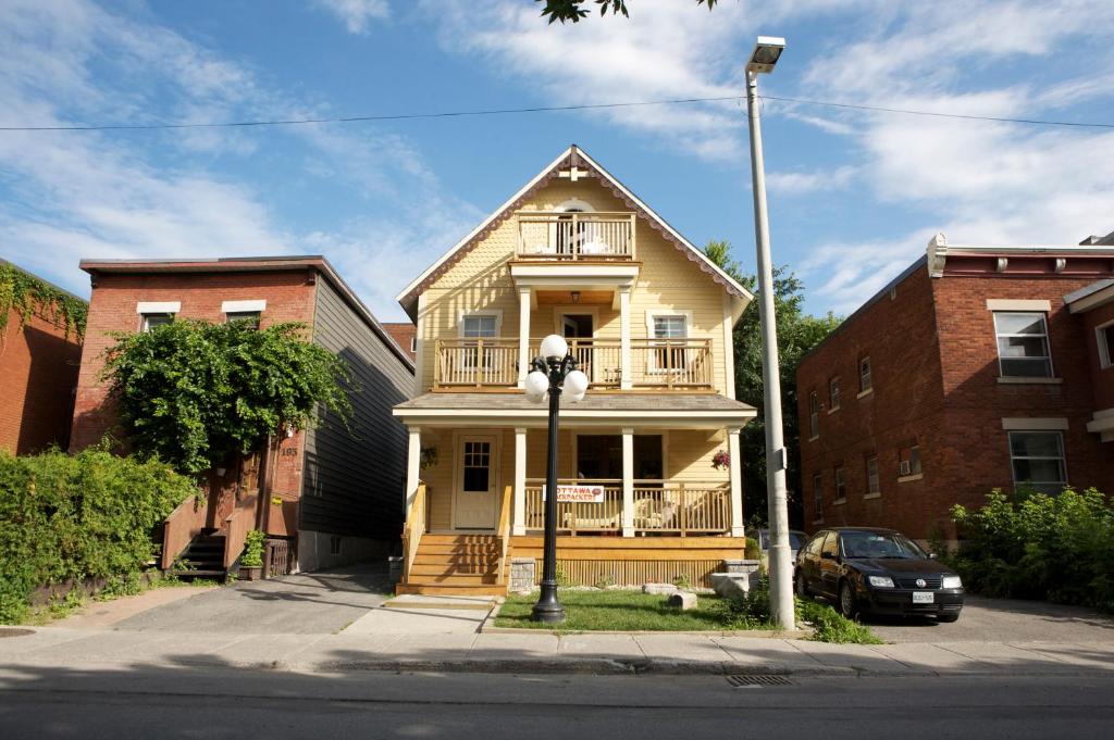 Casa amarilla con balcón en una calle en Ottawa Backpackers Inn, en Ottawa
