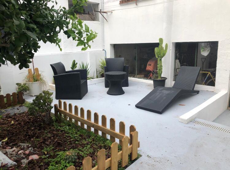 a patio with black chairs and a fence at Grandma`s house in Lisbon in Odivelas