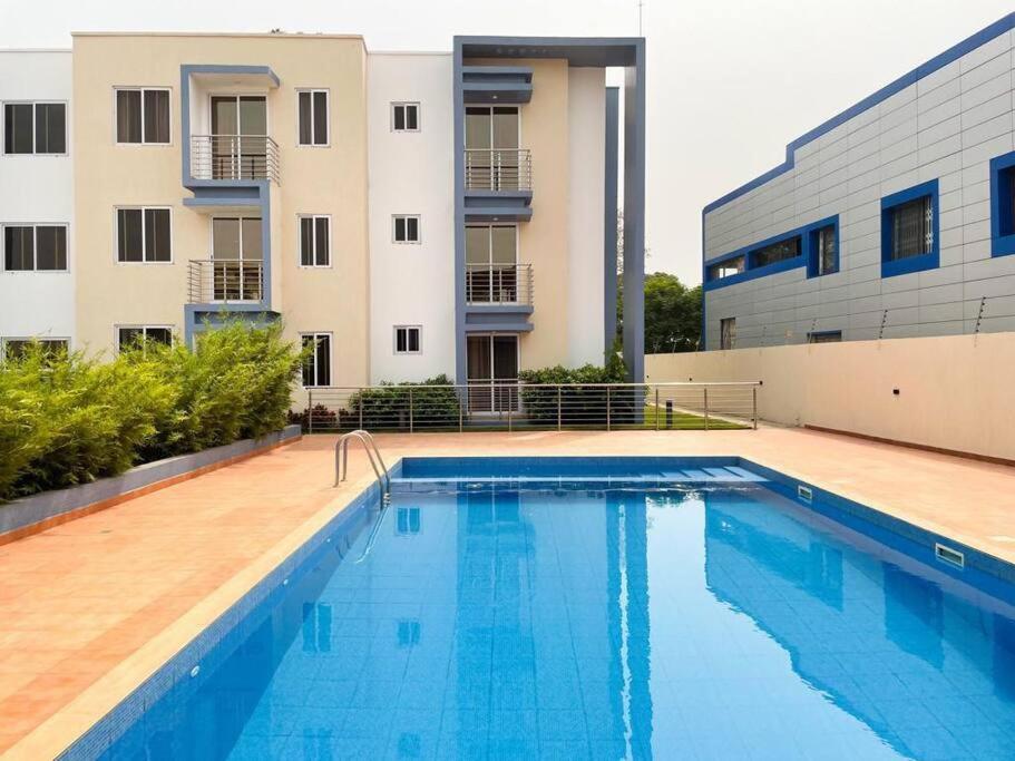 een groot zwembad voor een gebouw bij Cozy Airport Penthouse,Accra in Accra