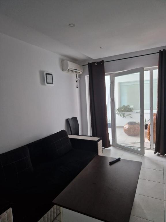 sala de estar con sofá negro y balcón en Maria Residence 2B, en Costinesti