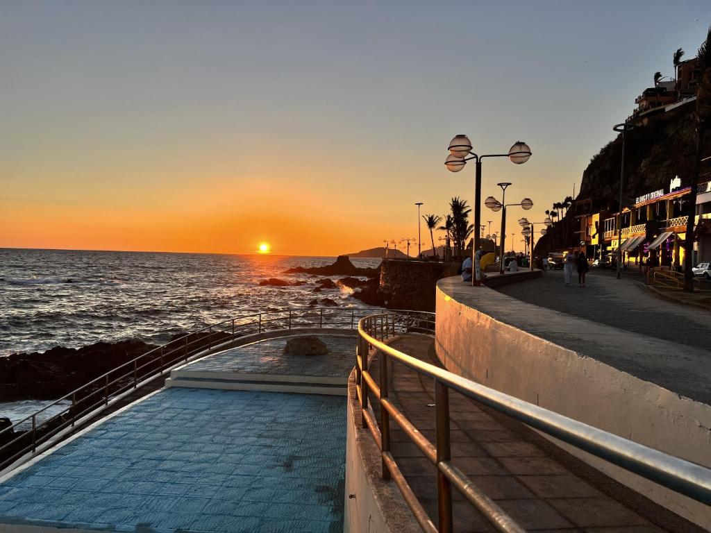 um pôr-do-sol sobre o oceano com uma piscina em Casa Carlota Mazatlán em Mazatlán