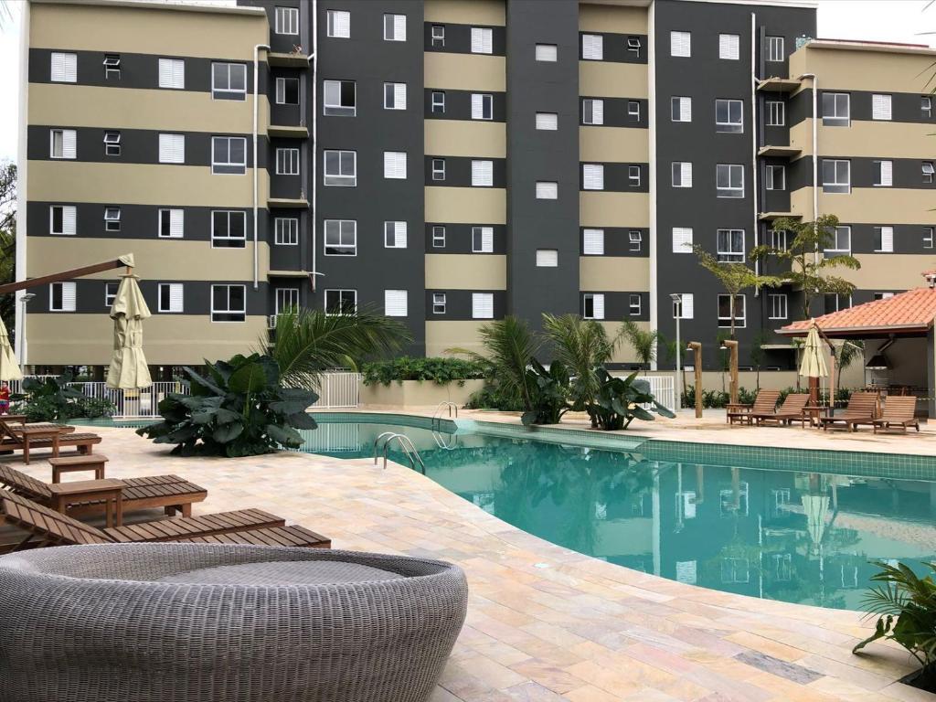 um hotel com piscina em frente a um prédio em Apartamento com piscina aquecida e churrasqueira em Ubatuba