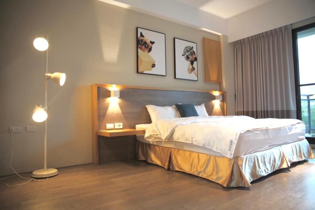 um quarto com uma cama grande e duas fotografias na parede em Sunny Sky Homestay em Yujing