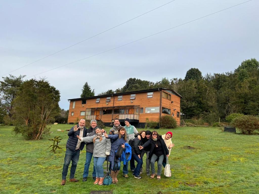 un grupo de personas posando para una foto frente a una casa en Hostal Hunter en Puerto Montt