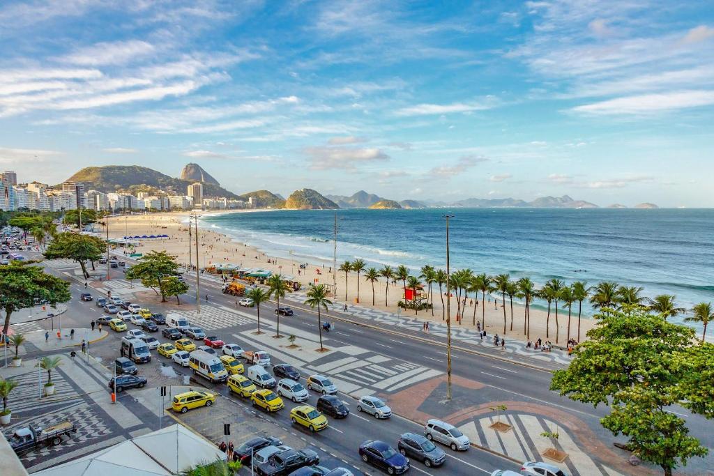 uma cidade com muitos carros estacionados na praia em Estúdio frente mar de Copacabana WIFI 500M no Rio de Janeiro