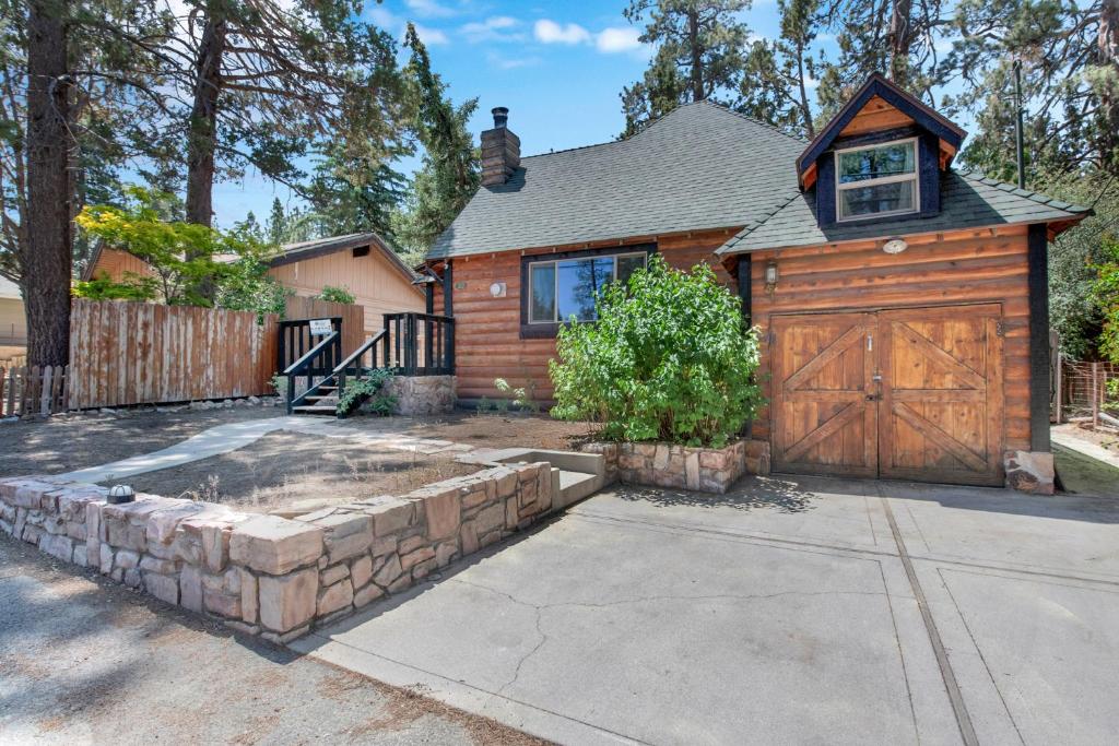 a house with a wooden garage and a fence at Maltby Modern Log Cabin Relaxing Chalet Retreat in Big Bear Lake
