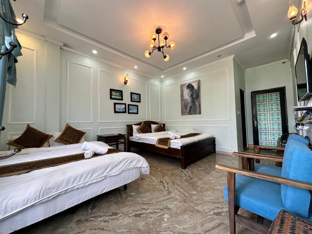 a hotel room with two beds and a couch at Ma Pi Leng Hotel in Dồng Văn