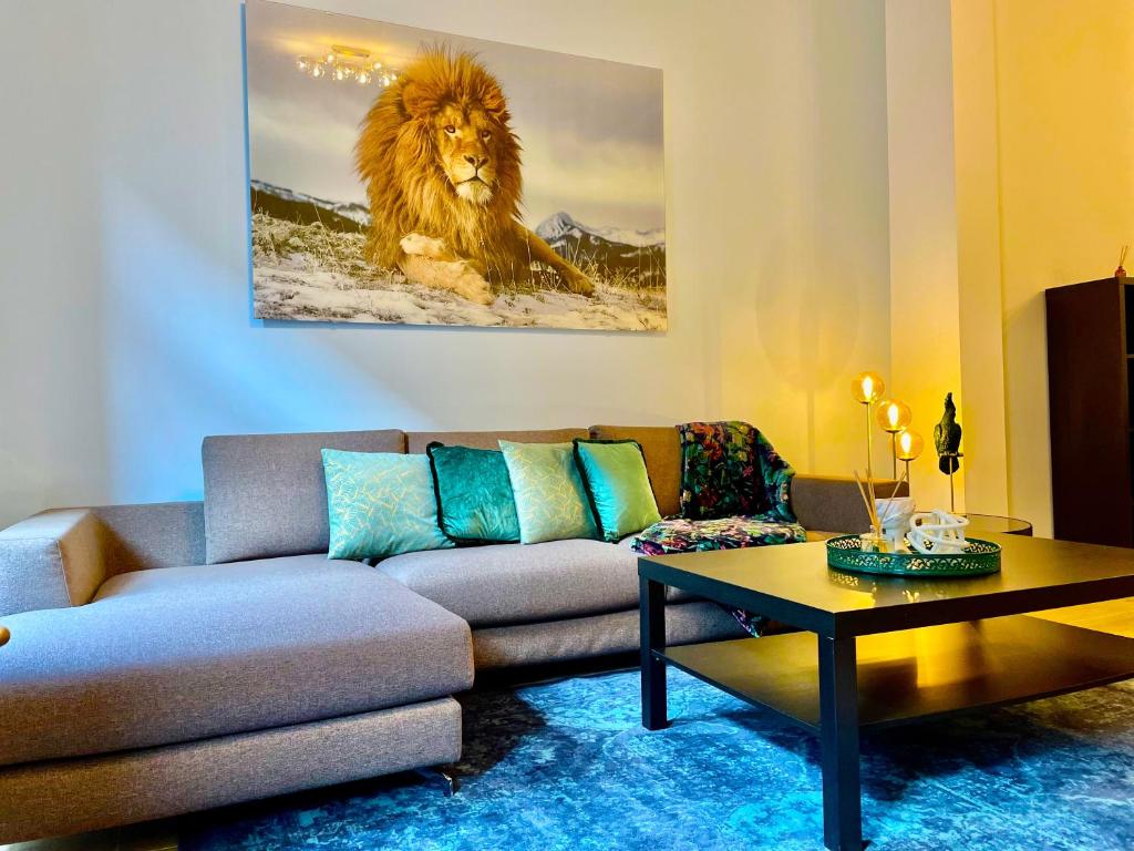 a living room with a couch and a lion painting at OneLuxStay near Fashion District in Antwerp