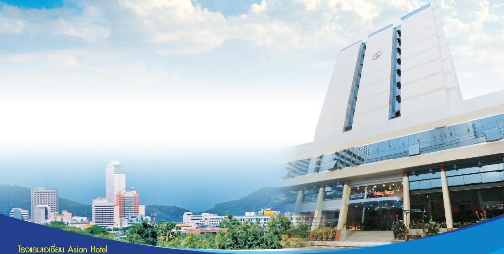 a large white building with a city in the background at Asian Hotel in Hat Yai