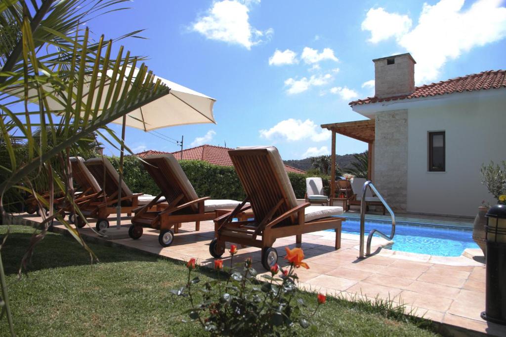 un grupo de sillas sentadas junto a una piscina en Eve Pissouri Veriko Villa, en Pissouri