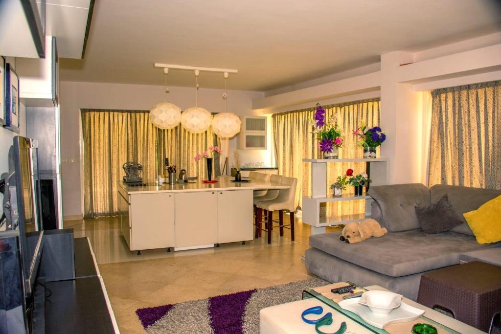 Villa 19, Amwaj Oyoun Resort - Beach- AquaPark Free Access في شرم الشيخ: غرفة معيشة مع أريكة ومطبخ