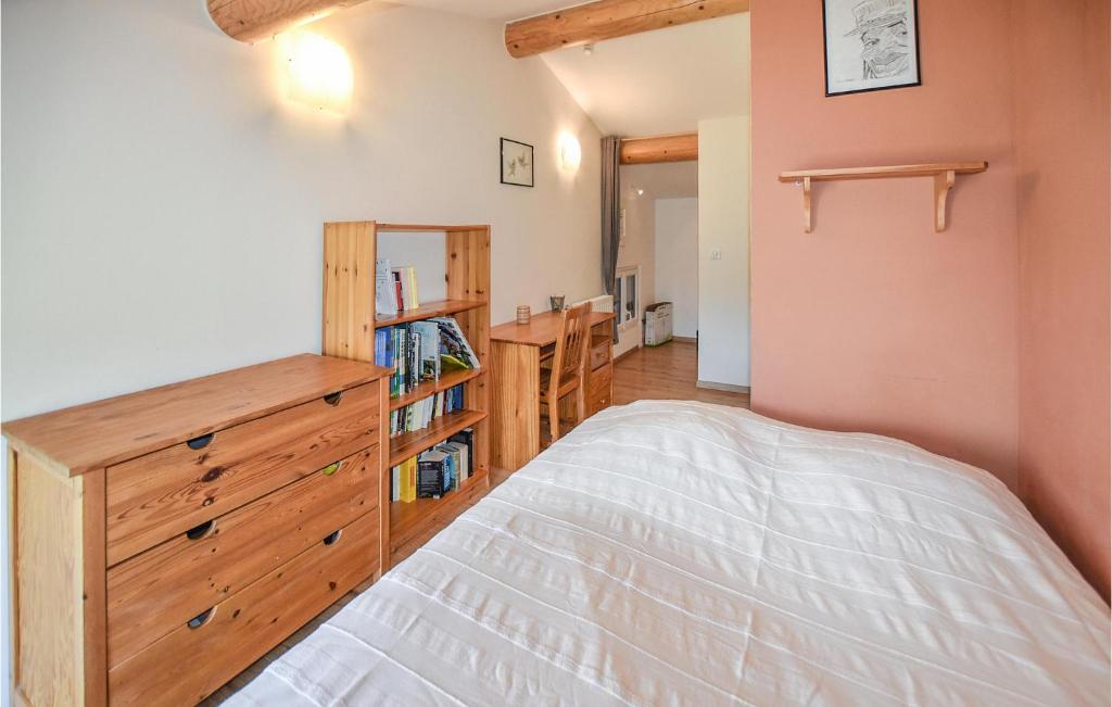 a bedroom with a bed and a wooden dresser at Nice Home In Taulignan With Wifi in Taulignan