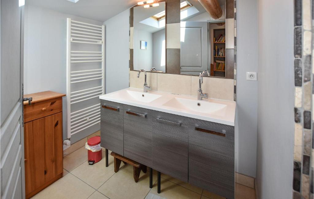 a bathroom with two sinks and a mirror at Nice Home In Taulignan With Wifi in Taulignan