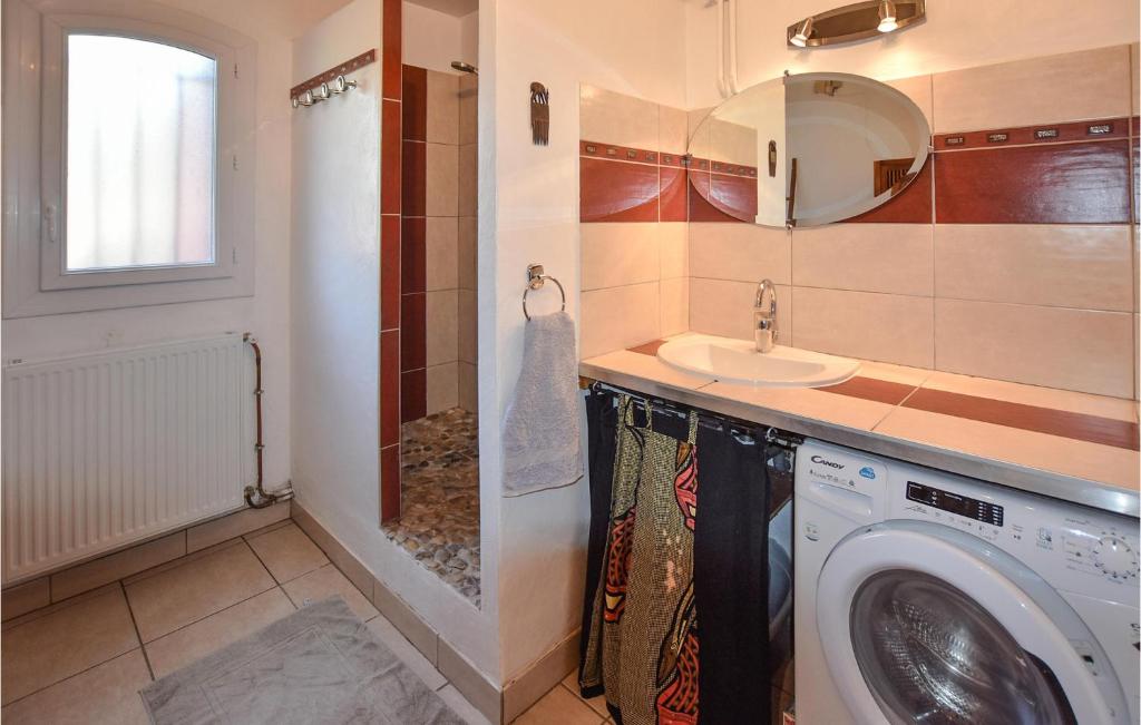 a bathroom with a washing machine and a sink at Nice Home In Taulignan With Wifi in Taulignan