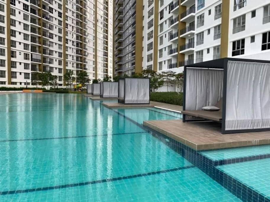uma piscina com água azul em frente a edifícios altos em Condo with pool-Muslim friendly em Kuala Lumpur