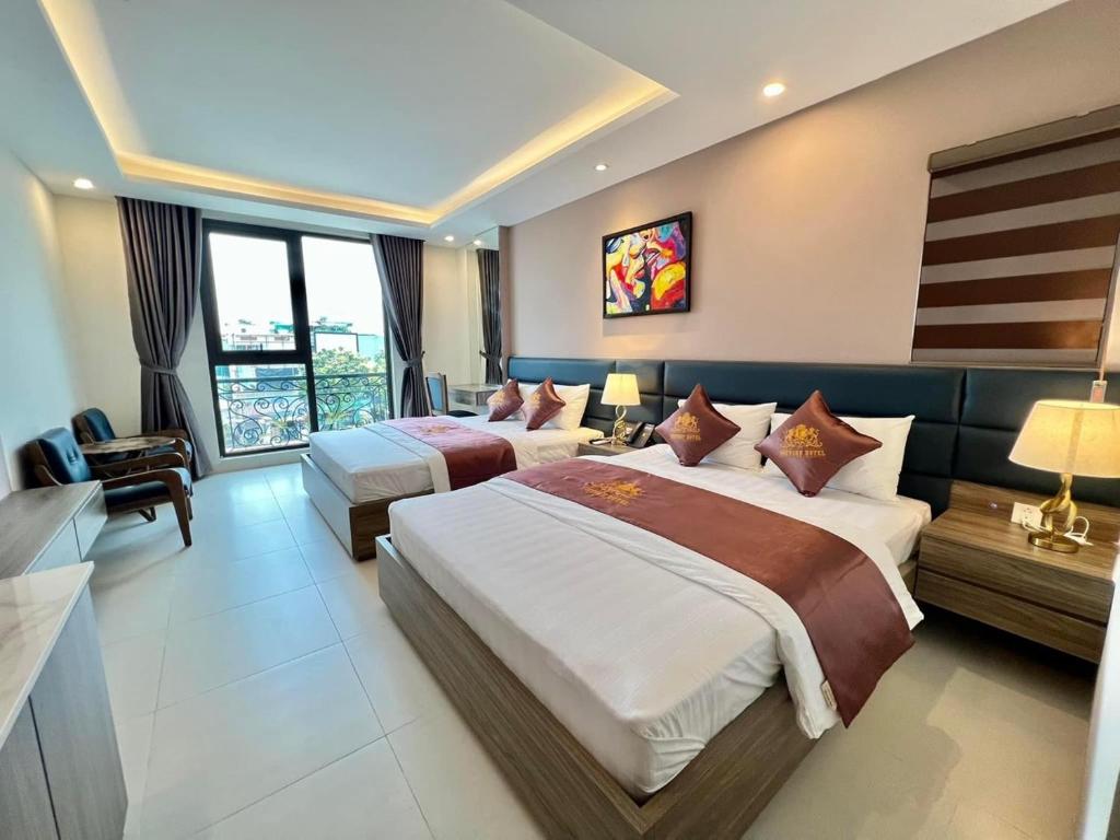 een hotelkamer met 2 bedden en een raam bij Victory Hotel in Hanoi