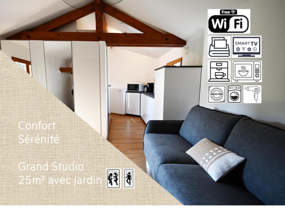 a living room with a blue couch and a kitchen at Studio * Confort * Sérénité * La halte du Pèlerin in Bures-sur-Yvette