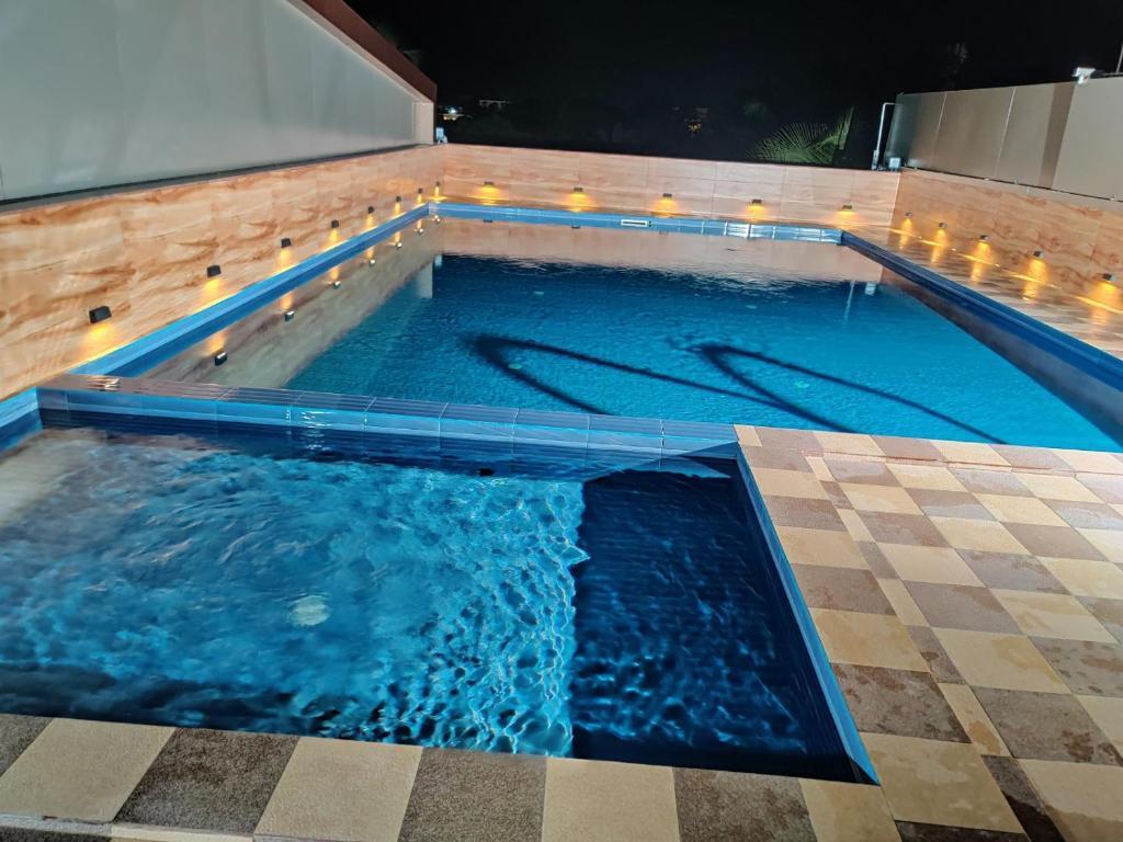 a swimming pool with blue water in a building at Hotel Newline Orchid in Guruvāyūr