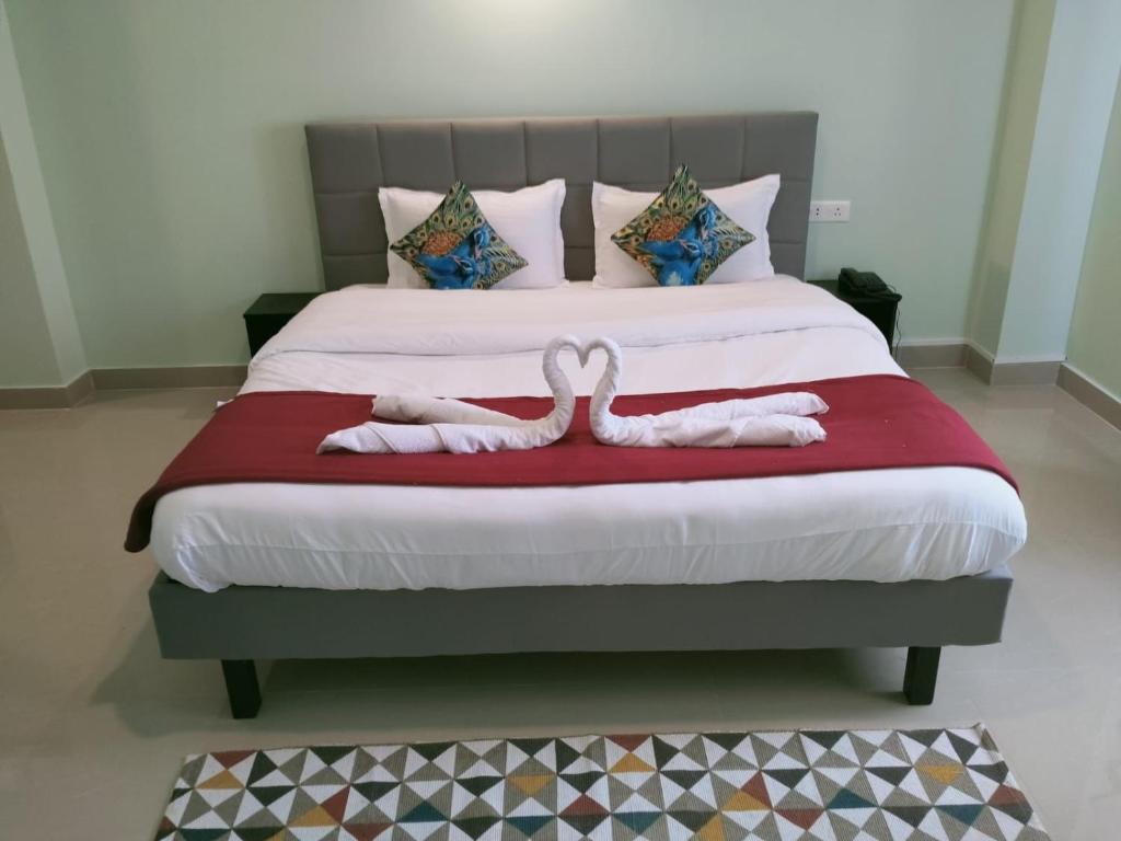 two towels in the shape of hearts are on a bed at Hotel BJ in Gangtok