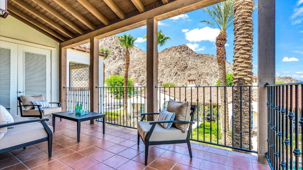 a porch with chairs and a balcony with palm trees at LV204 Airy Upstairs 2 Bedroom w Private Balcony in La Quinta