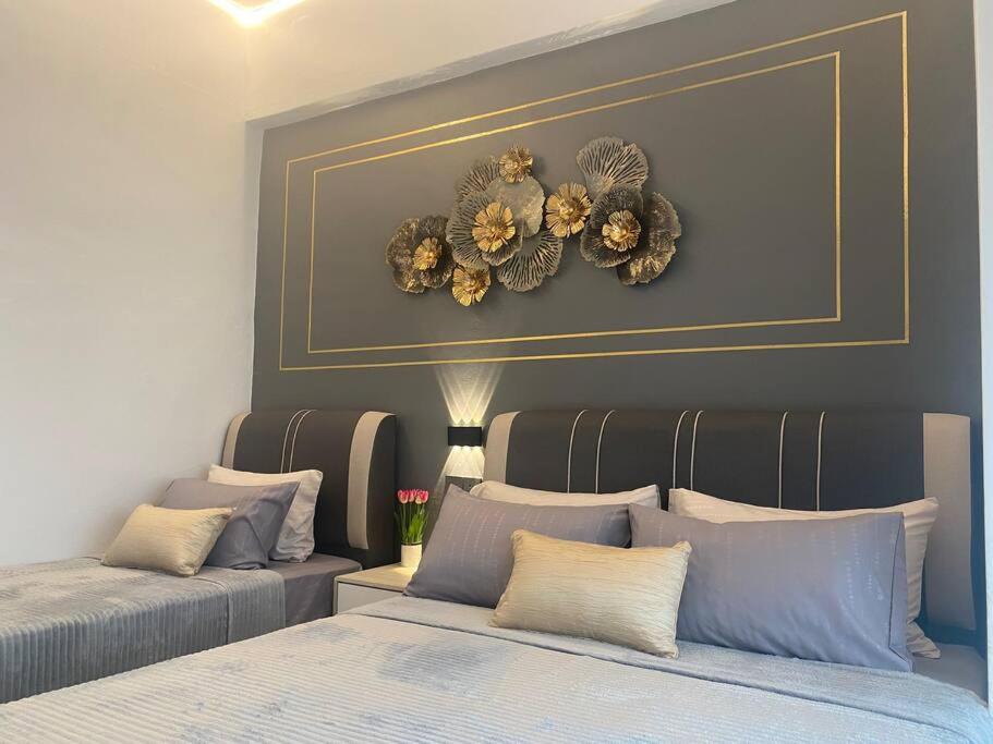a bedroom with two beds and areath on the wall at My Cozy 2-bedroom Apartment in Melaka