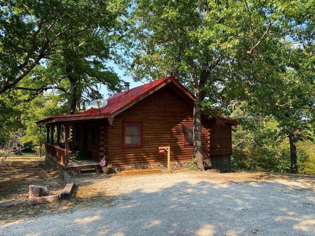 Cabaña de madera pequeña con techo rojo en Cozy Cabin at Bear Mountain Log Cabins en Eureka Springs