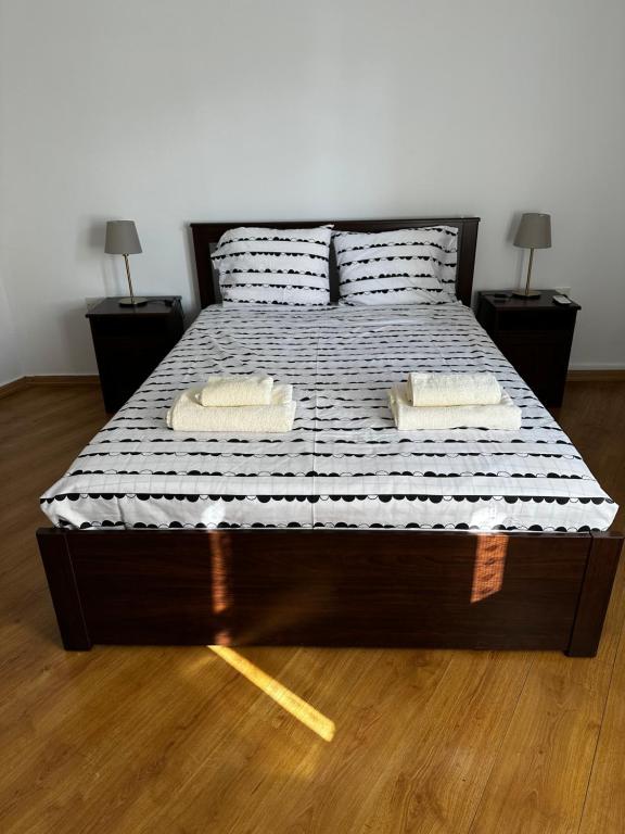 ein Bett mit zwei Kissen darauf und zwei Tischen in der Unterkunft Spitaki in Polis Chrysochous
