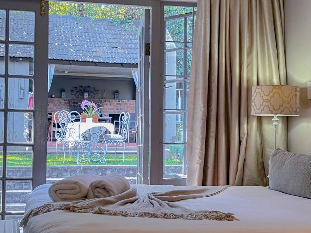 Rúm í herbergi á Amoris Guesthouse In Waterkloof Ridge