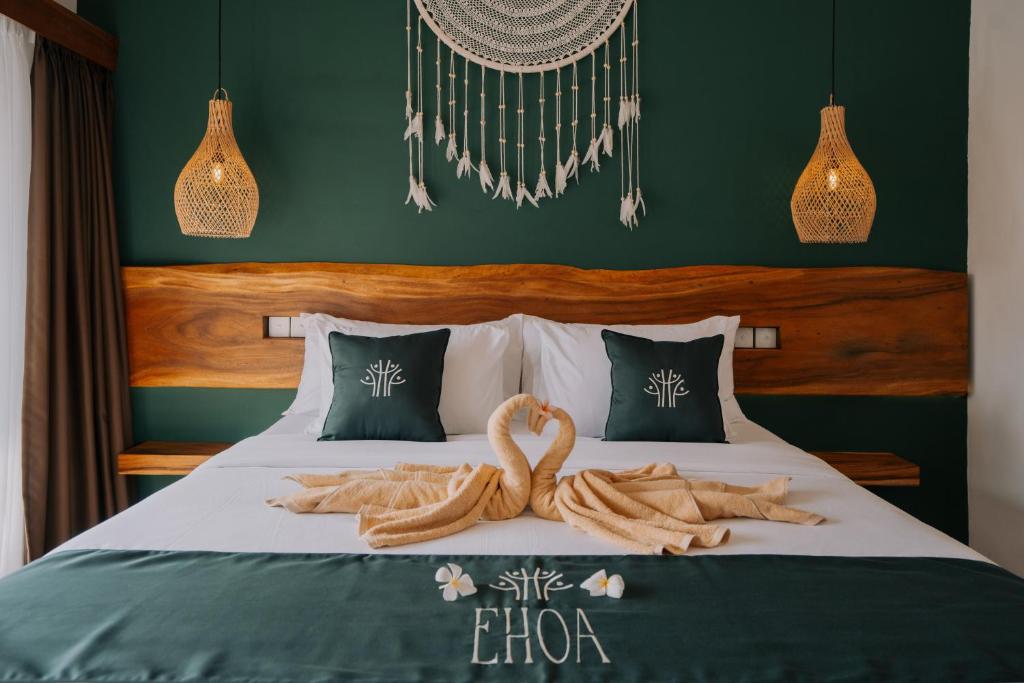 a bedroom with a bed with a wooden head board at EHOA BALI Nyanyi Boutique Hotel - In front of entrance to NUANU in Tanah Lot