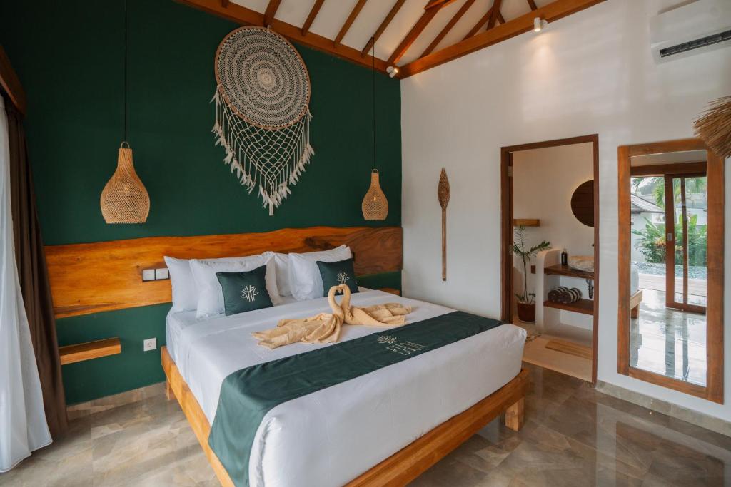 a bedroom with a bed with a green wall at EHOA BALI Nyanyi Boutique Hotel - In front of entrance to NUANU in Tanah Lot