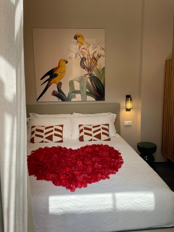 a bed with a heart made out of red roses at 3L Luxury Rooms in La Spezia